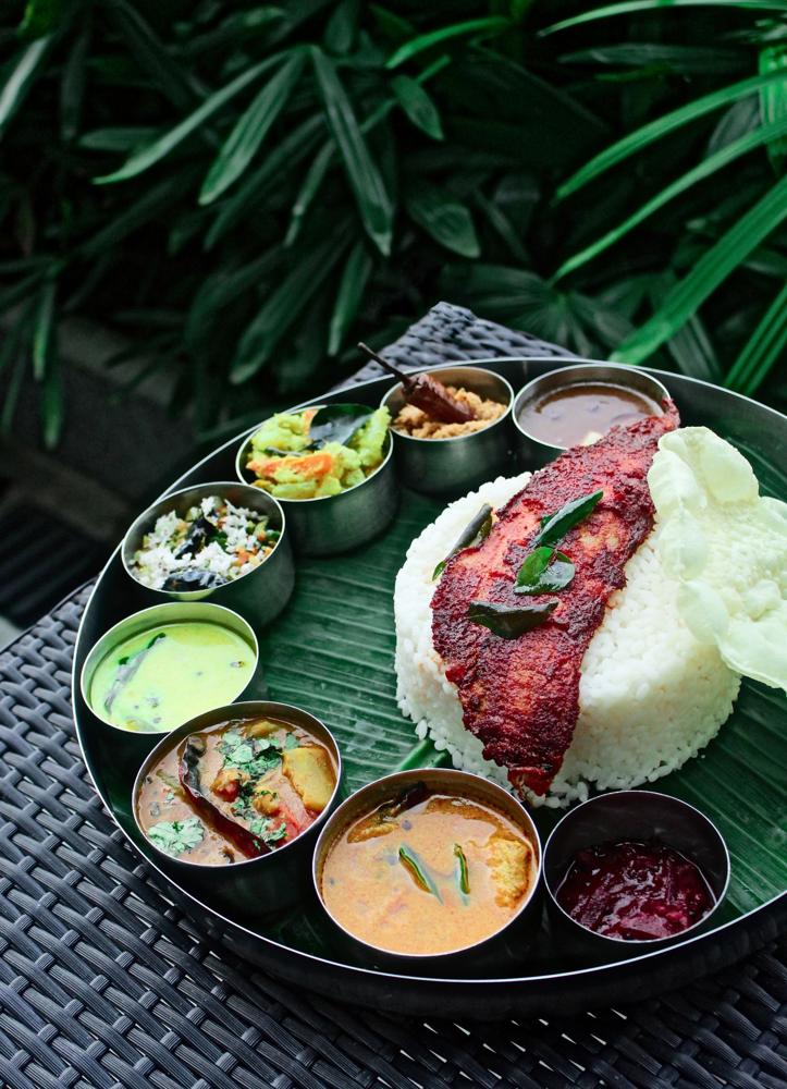 Kerala rice meal with curries and fried fish on banana leaf